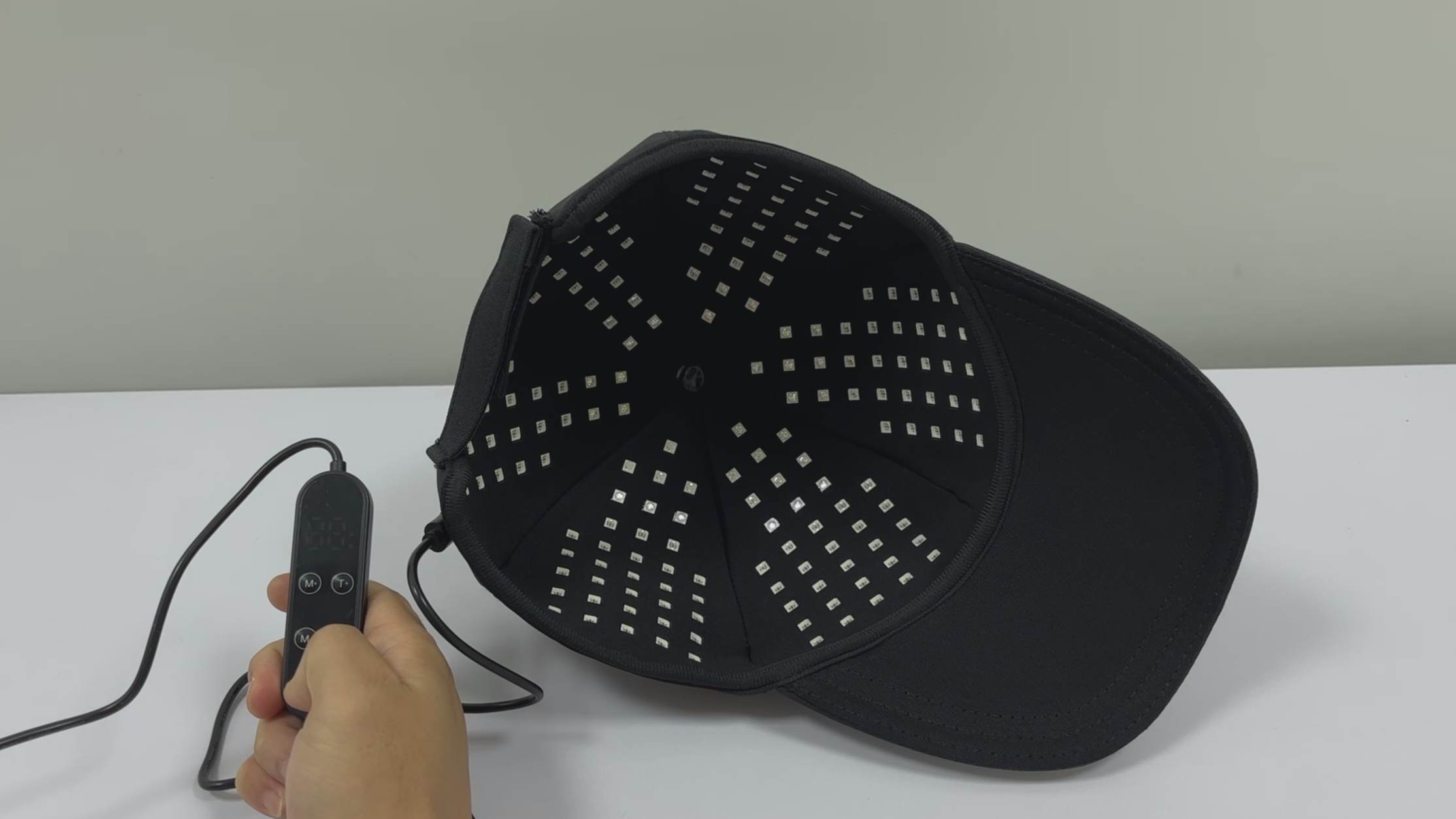 Inner surface of the black cap with the LEDs switched off and the connected controller beside it