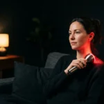 Handheld red light therapy flashlight used on the neck at home